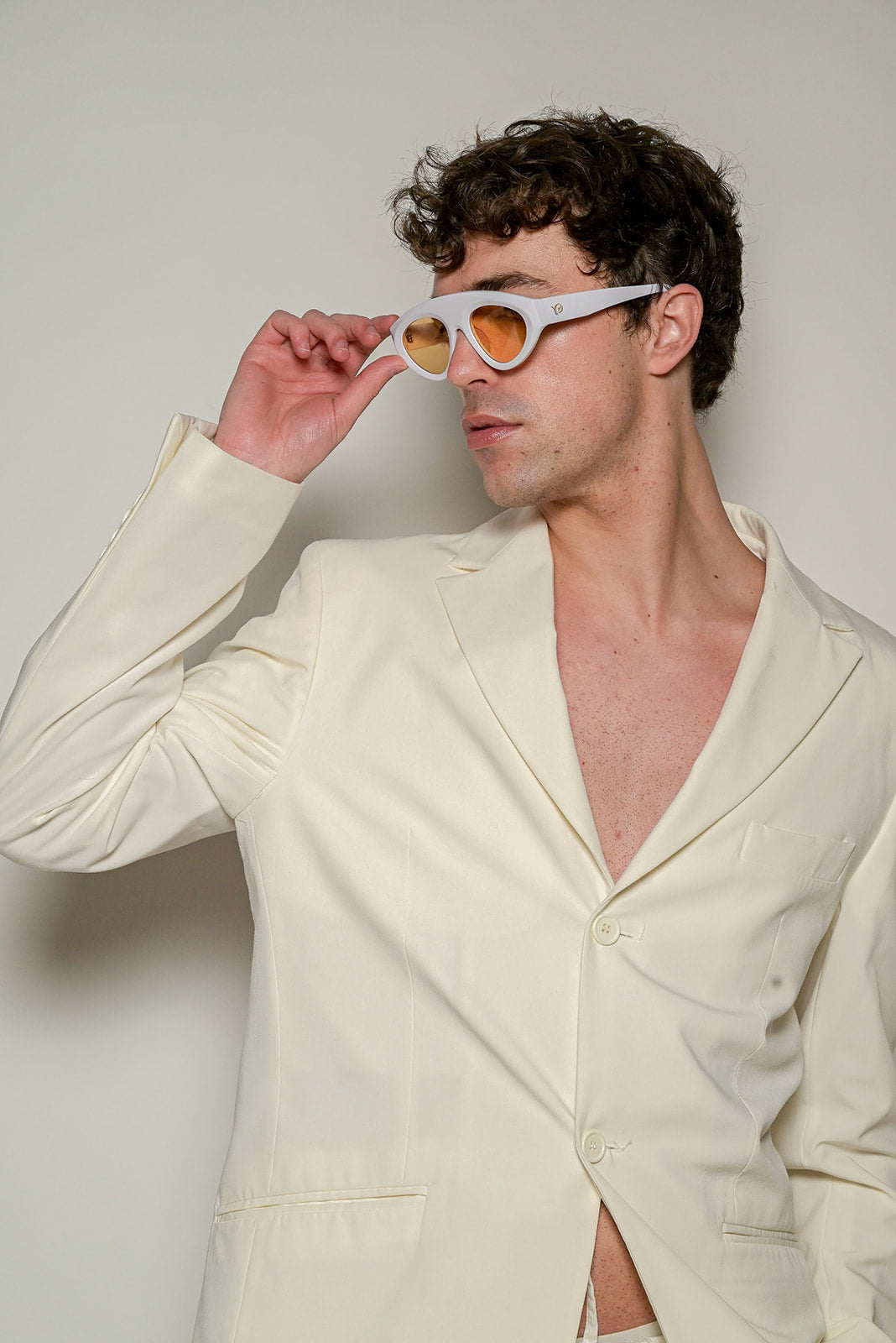 Homme qui porte des Lunettes de soleil blanches aux lignes épurées et lumineuses de la marque VROC. 