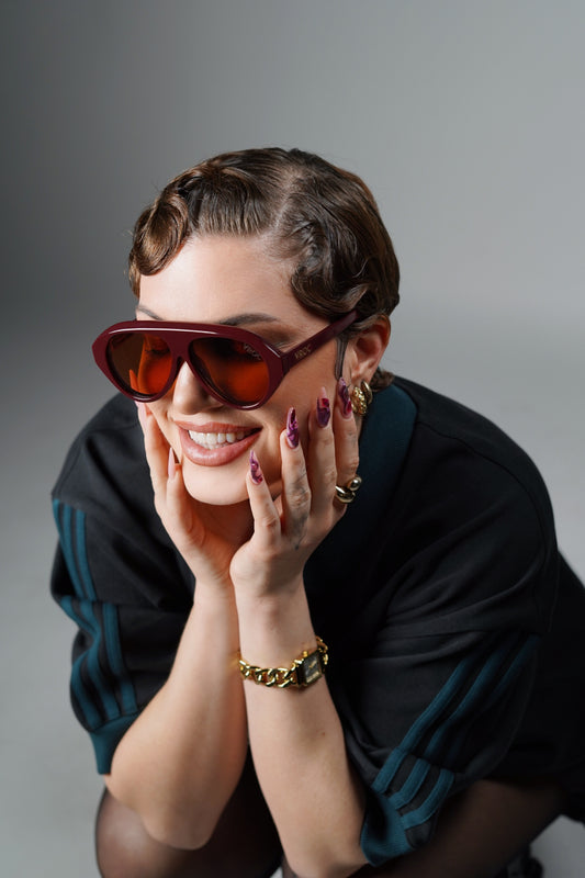 femme avec des Lunettes de soleil de la marque VROC bordeaux profond aux reflets intenses.