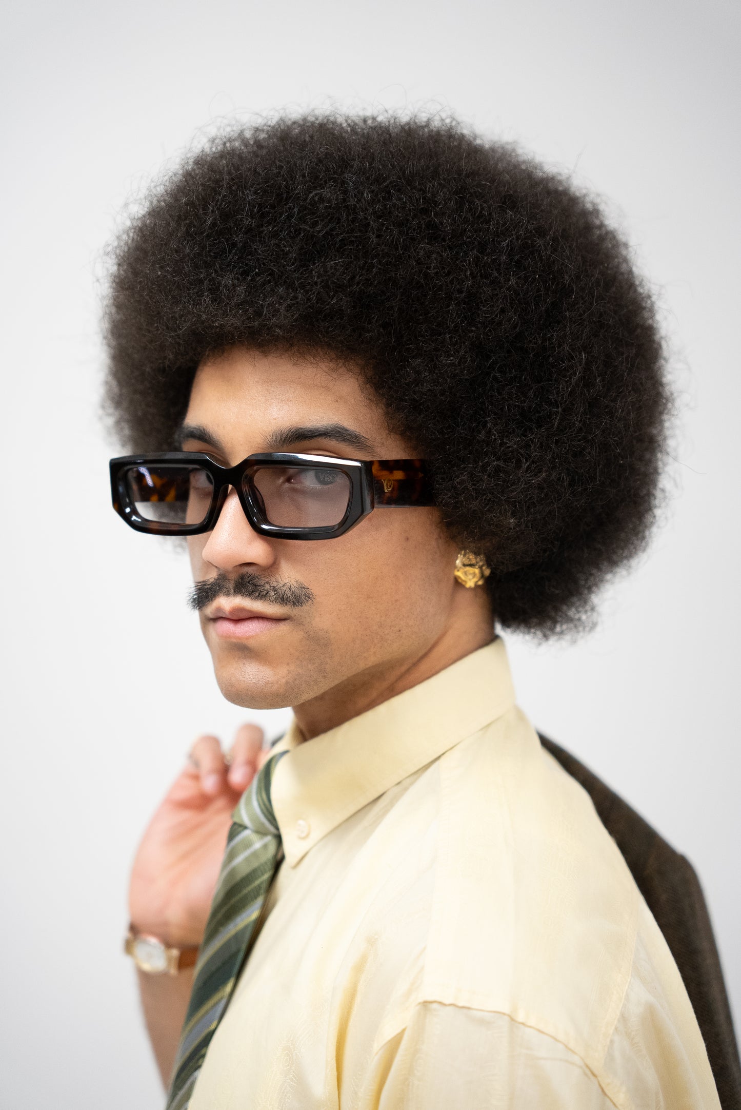 Photo d'un homme de profil qui porte des Lunettes de soleil écaille marron aux nuances chaudes et naturelles de la marque VROC. 