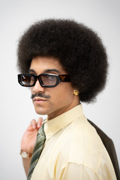 Photo d'un homme de profil qui porte des Lunettes de soleil écaille marron aux nuances chaudes et naturelles de la marque VROC. 