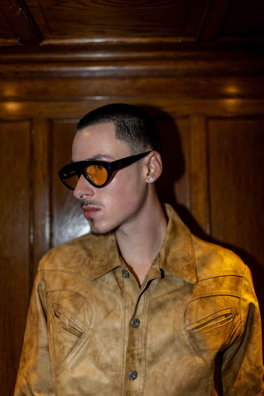 Homme qui porte Lunettes de soleil noires aux verres subtilement teintés de tons chauds de la marque VROC. 