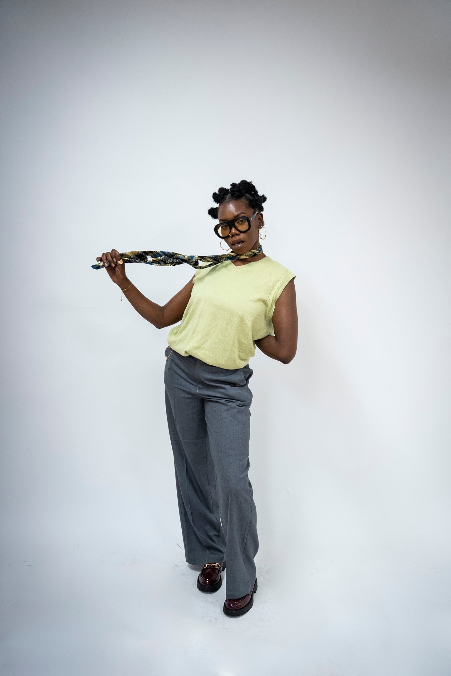 Photo d'une femme qui porte des Lunettes de soleil noires aux verres teintés jaune doré de la marque VROC. 