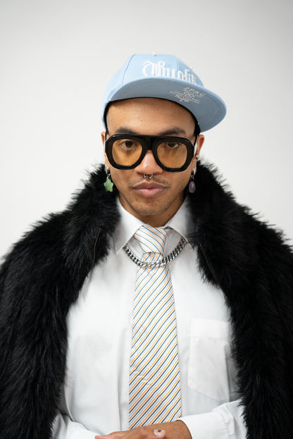 Photo homme qui porte des Lunettes de soleil noires aux verres teintés jaune doré de la marque VROC. 