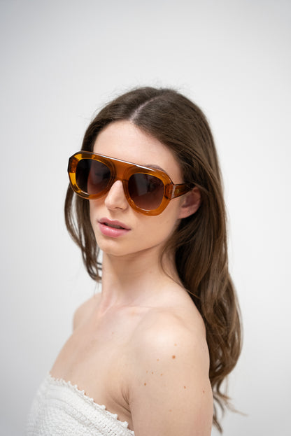femme qui porte des. Lunettes de soleil orange translucide aux teintes ambrées profondes de la marque VROC. 