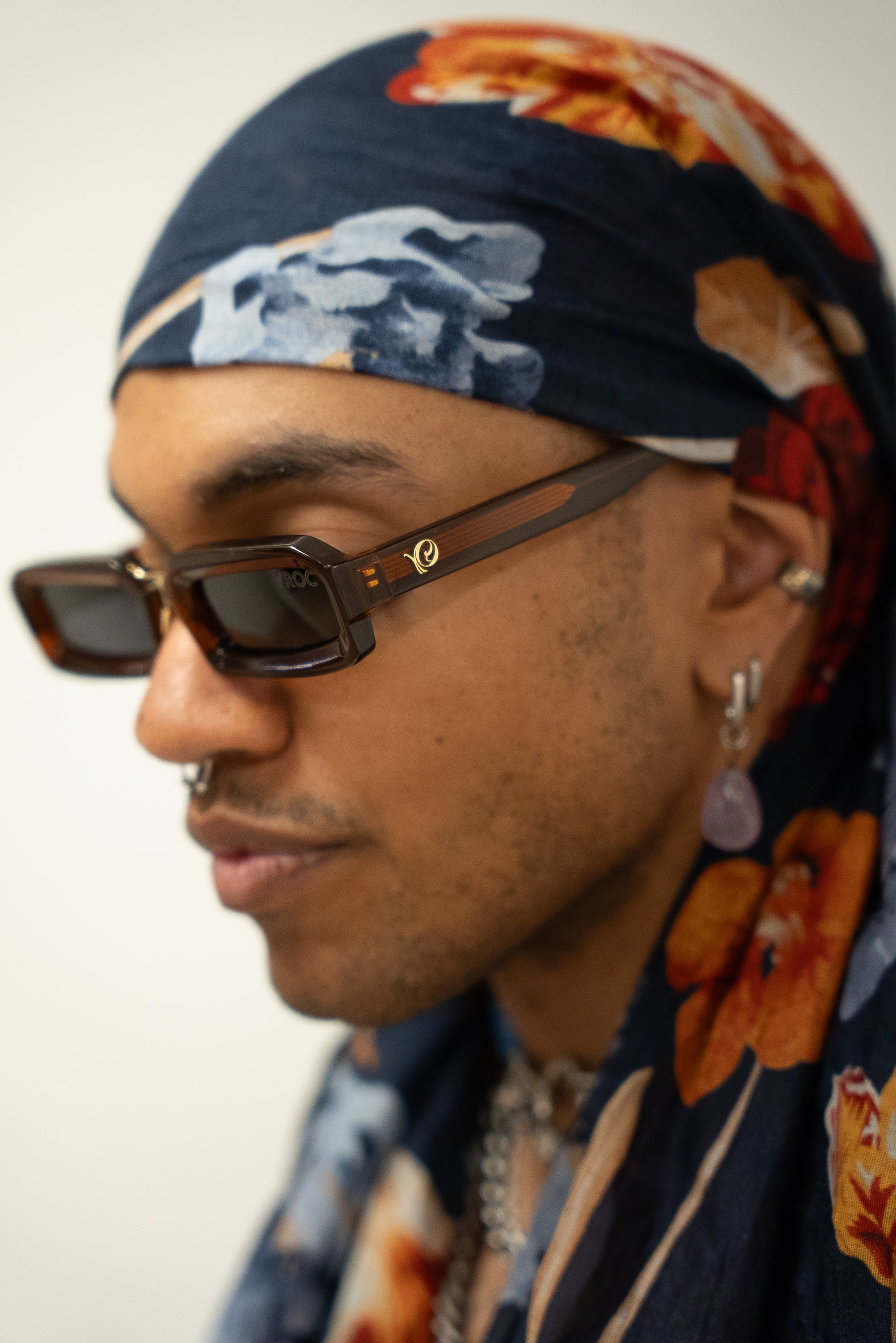 photo d'un homme qui Lunettes de soleil translucides aux teintes ambrées et chaleureuses de la marque VROC.